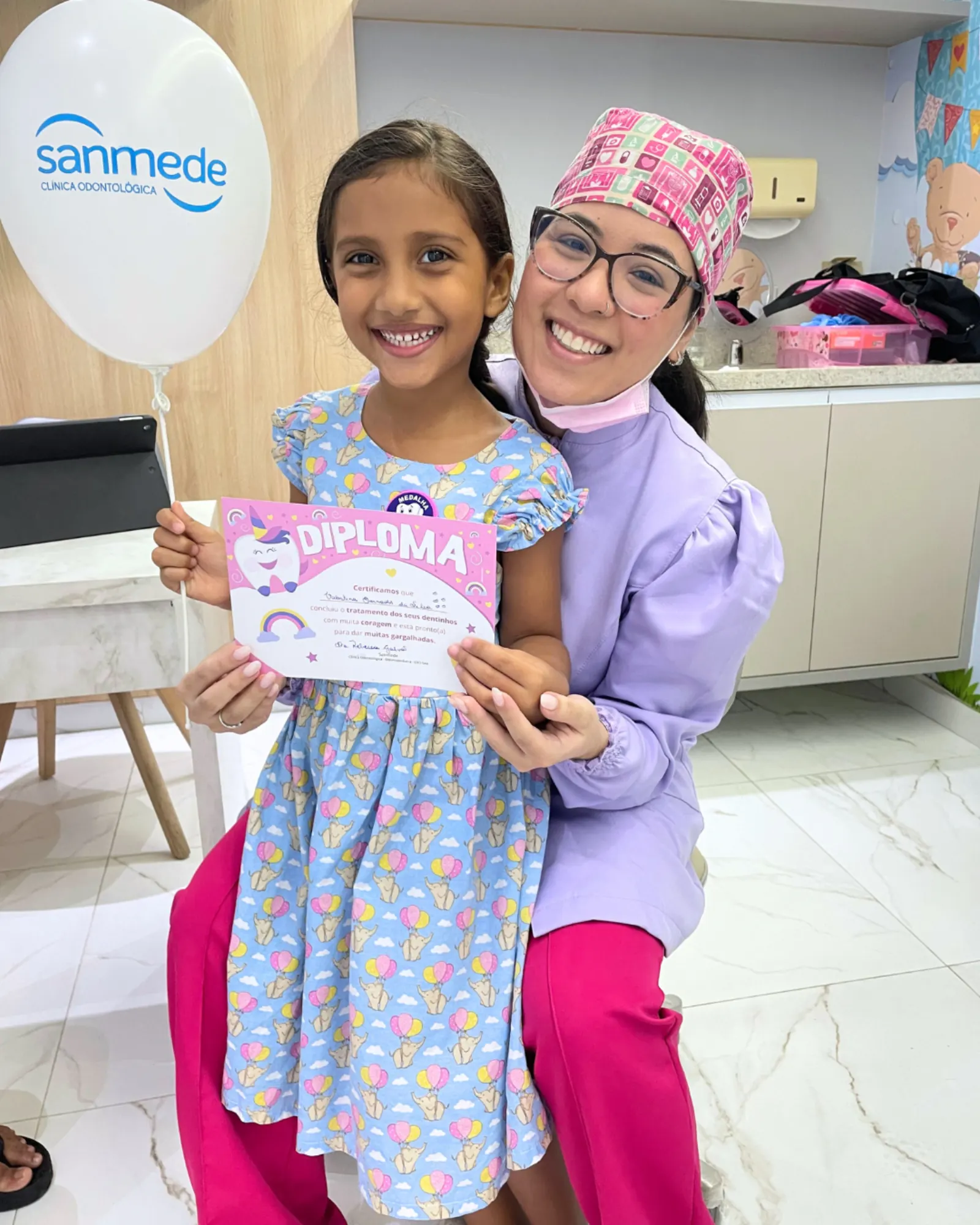 Paciente infantil recebendo diploma após tratamento